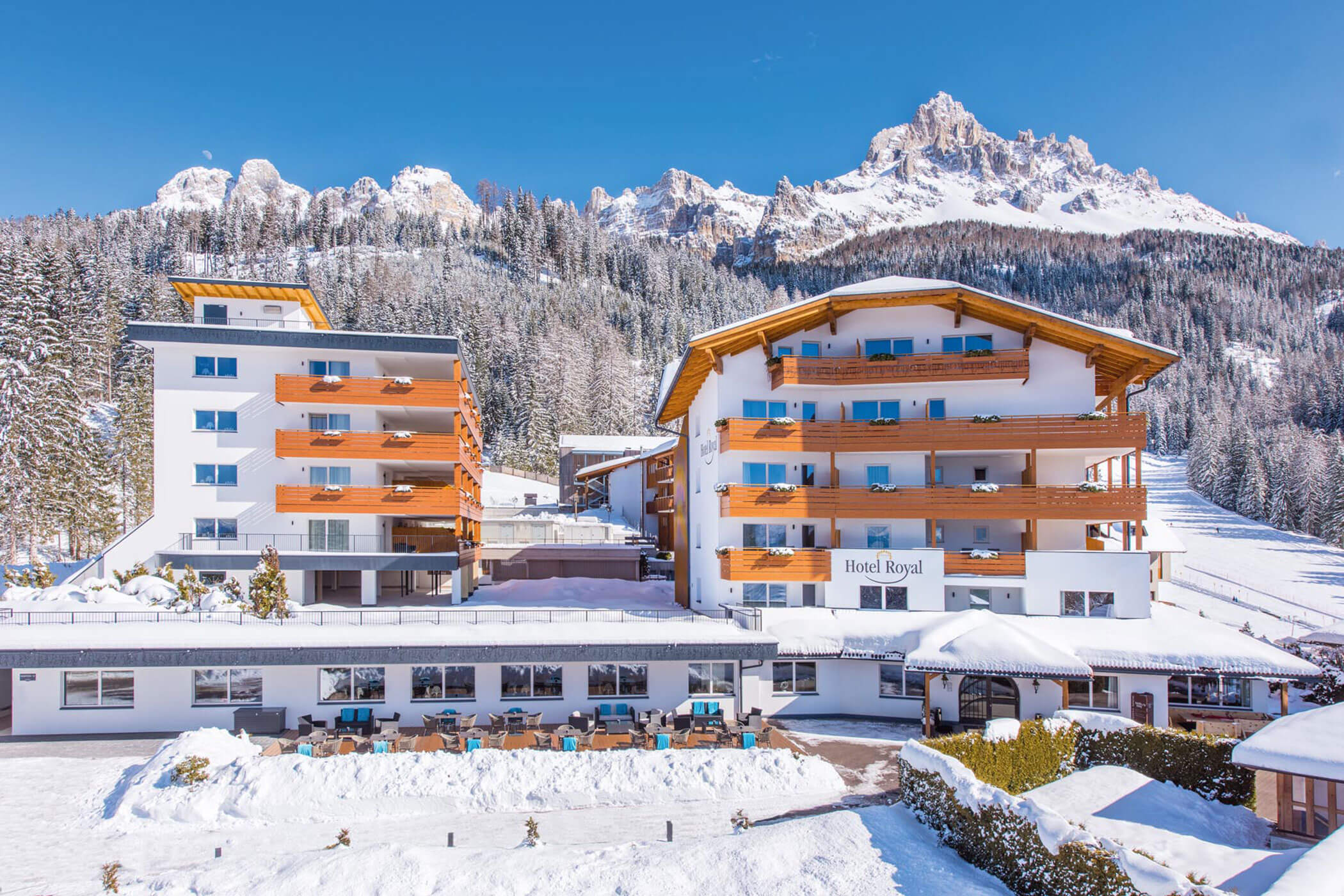 Die Gebäude des Hotel Royal Resorts liegen eingebettet in einer schneebedeckten Berglandschaft. - Hotel DAS ROYAL