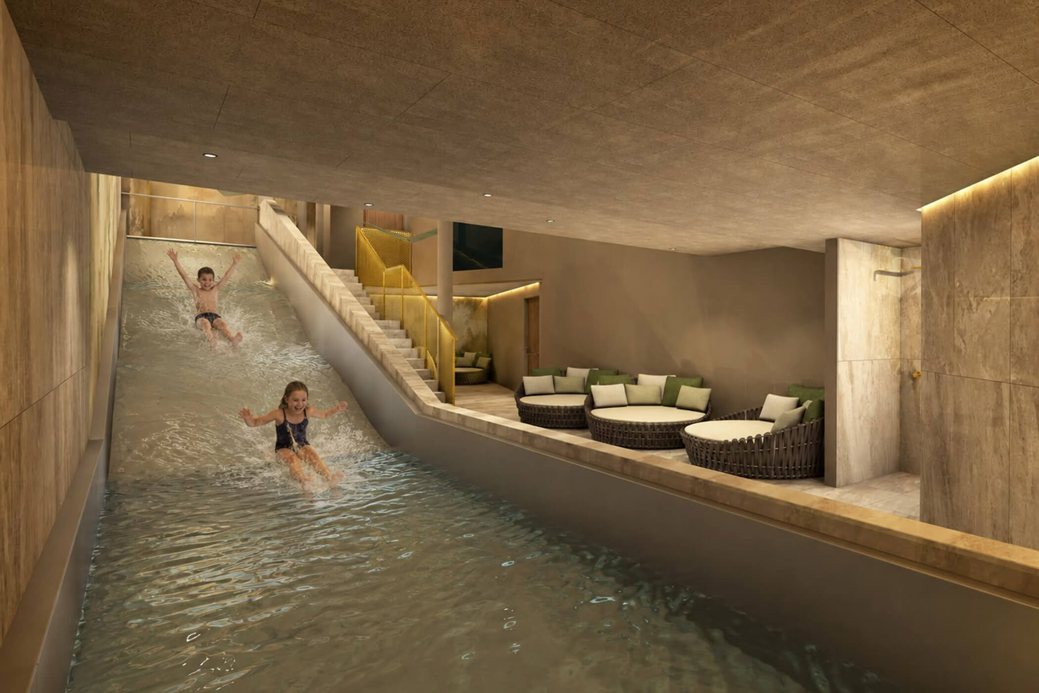 Zwei Kinder rutschen auf einer Wasserrutsche in einen Pool in einem Loungebereich hinunter. - Hotel DAS ROYAL